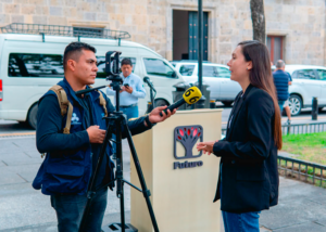 Portada del boletín agosto de 2023. Susana de la Rosa habla ante las cámaras de canal 6 de Guadalajara. Al fondo, la fachada y puerta del Congreso del Estado de Jalisco